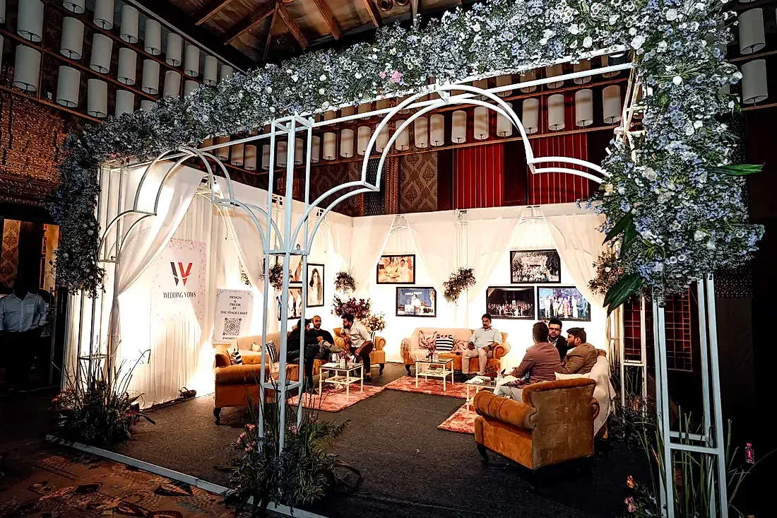 A floral-canopy premium lounge with buyers in conversation