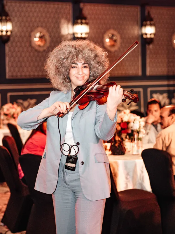 A violinist performing among the delegates