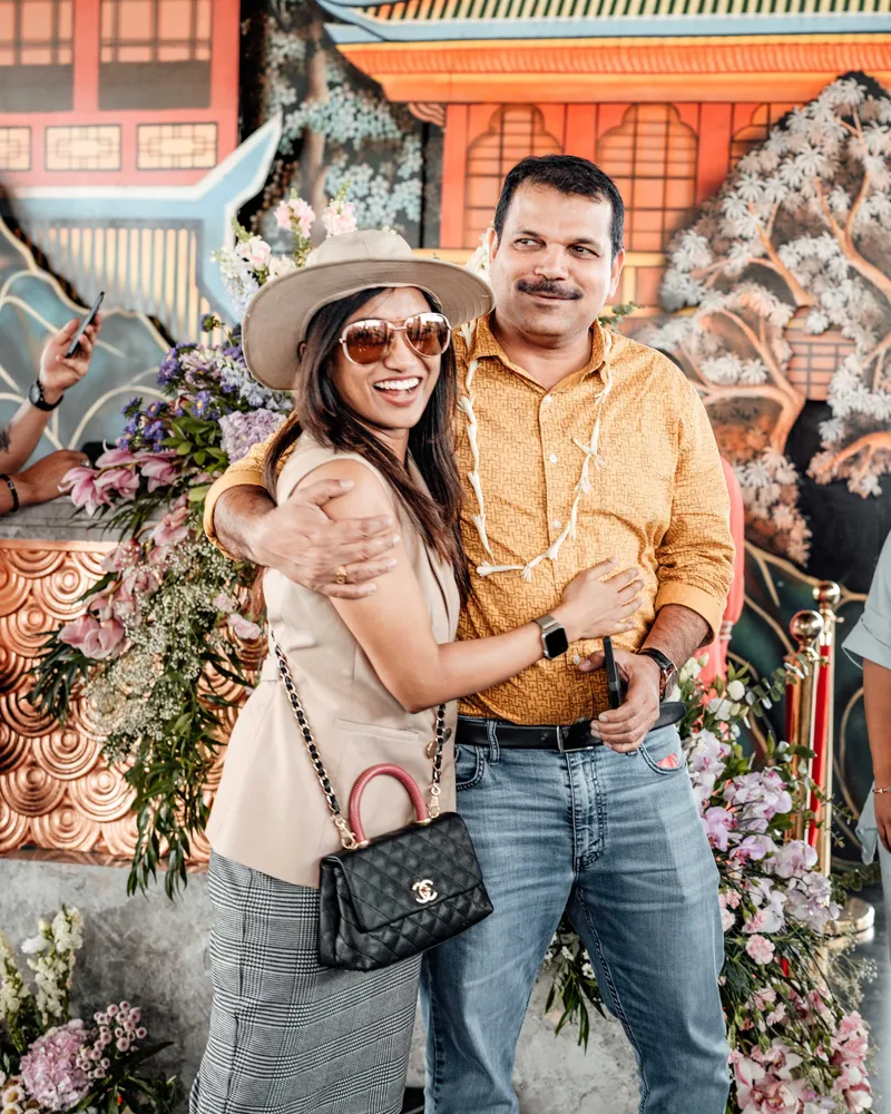 Two delegates embracing in front of the floral installation