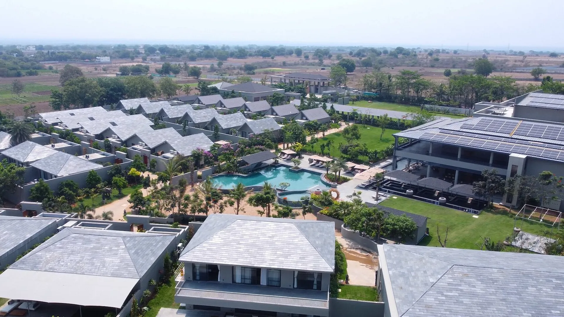 Arth Resort & Spa from the air — villas, lawns and the central pool